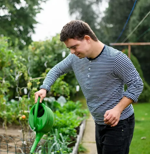 A young NDIS participant building skills and confidence while gardening outdoors